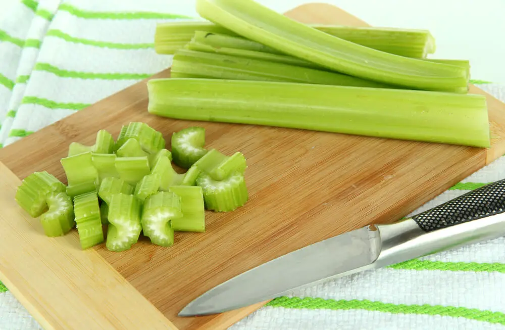 sliced celery on a wooden chopboard
