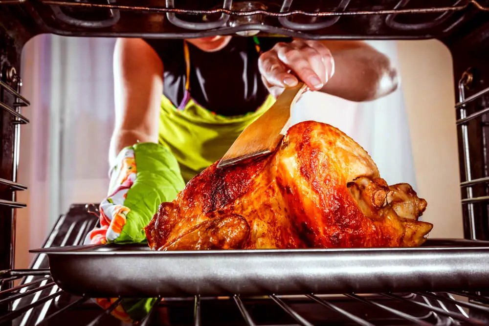 woman placed turkey in the oven in order to cook it 